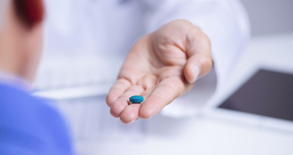 Médico entregando uma pílula azul de Viagra para paciente